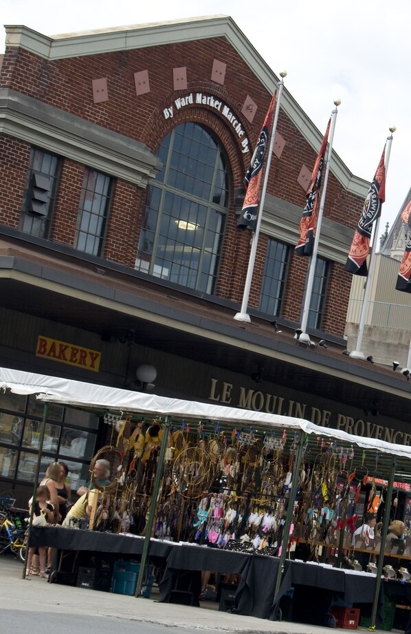A brick building with a bakery sign and a market stall selling various items. - Les Suites Hotel Ottawa (Ottawa)