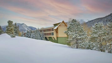 Un albergue con un cartel que dice "Keystone Lodge & Spa" rodeado de árboles y montañas cubiertas de nieve.