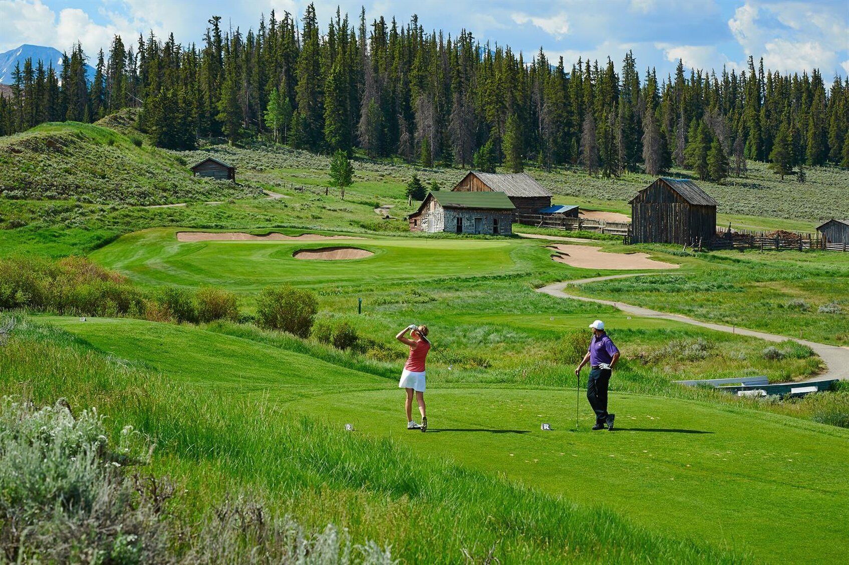 A golf course with bunkers, a tee box, and a putting green.