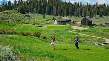 A golf course with bunkers, a tee box, and a putting green.