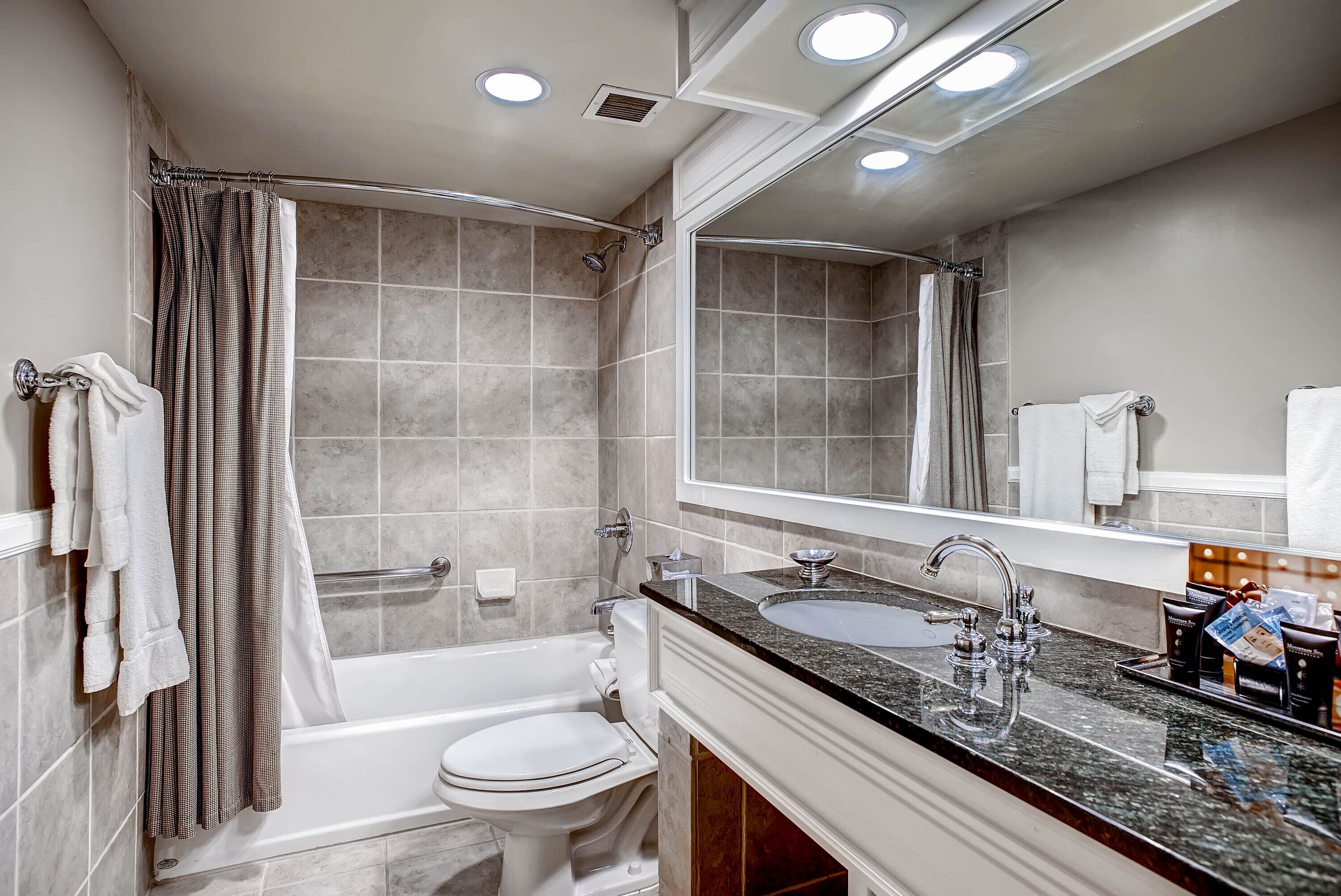 A modern bathroom with a bathtub, toilet, and sink.