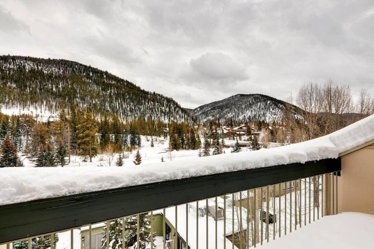 A snowy mountain landscape with a balcony railing.