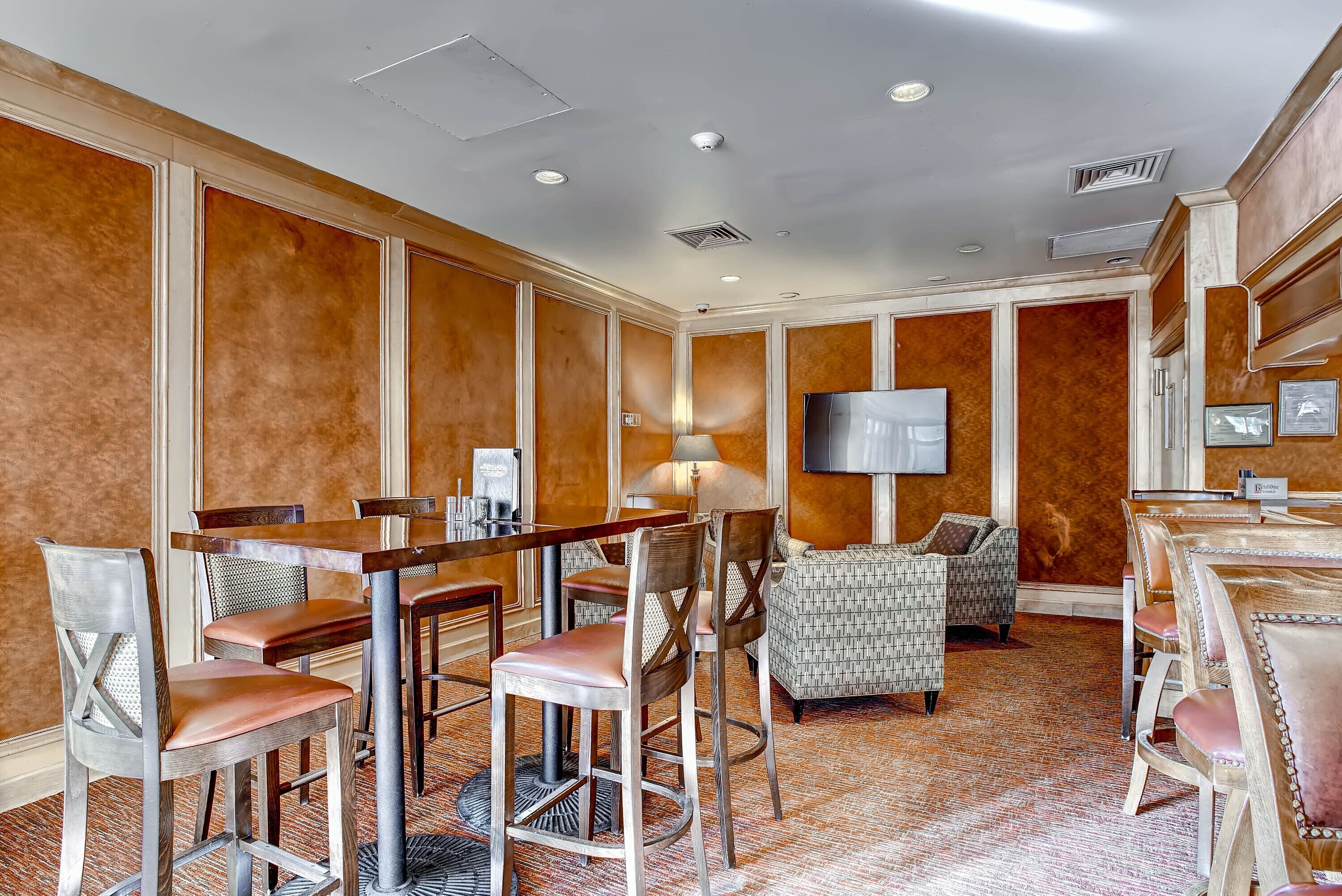 A hotel room with a dining area, a sofa, and a TV.