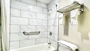Ein Badezimmer mit Badewanne, Handtuchhalter und Duschkopf.