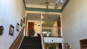 A staircase with a wooden handrail and a ceiling fan.