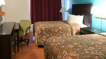 Une chambre d’hôtel avec deux lits, un bureau, une chaise, une lampe et un téléviseur.