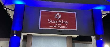 A hotel entrance with a SureStay Plus sign, indicating a partnership with Best Western.