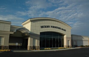 A building with a large arched entrance and the sign 'HICKORY FURNITURE MART' above it. - Crowne Plaza Hotel Hickory by IHG (Hickory)