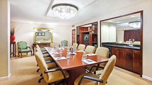 A conference room with a long table, chairs, a television, and a kitchen area. - Crowne Plaza Hotel Hickory by IHG (Hickory)