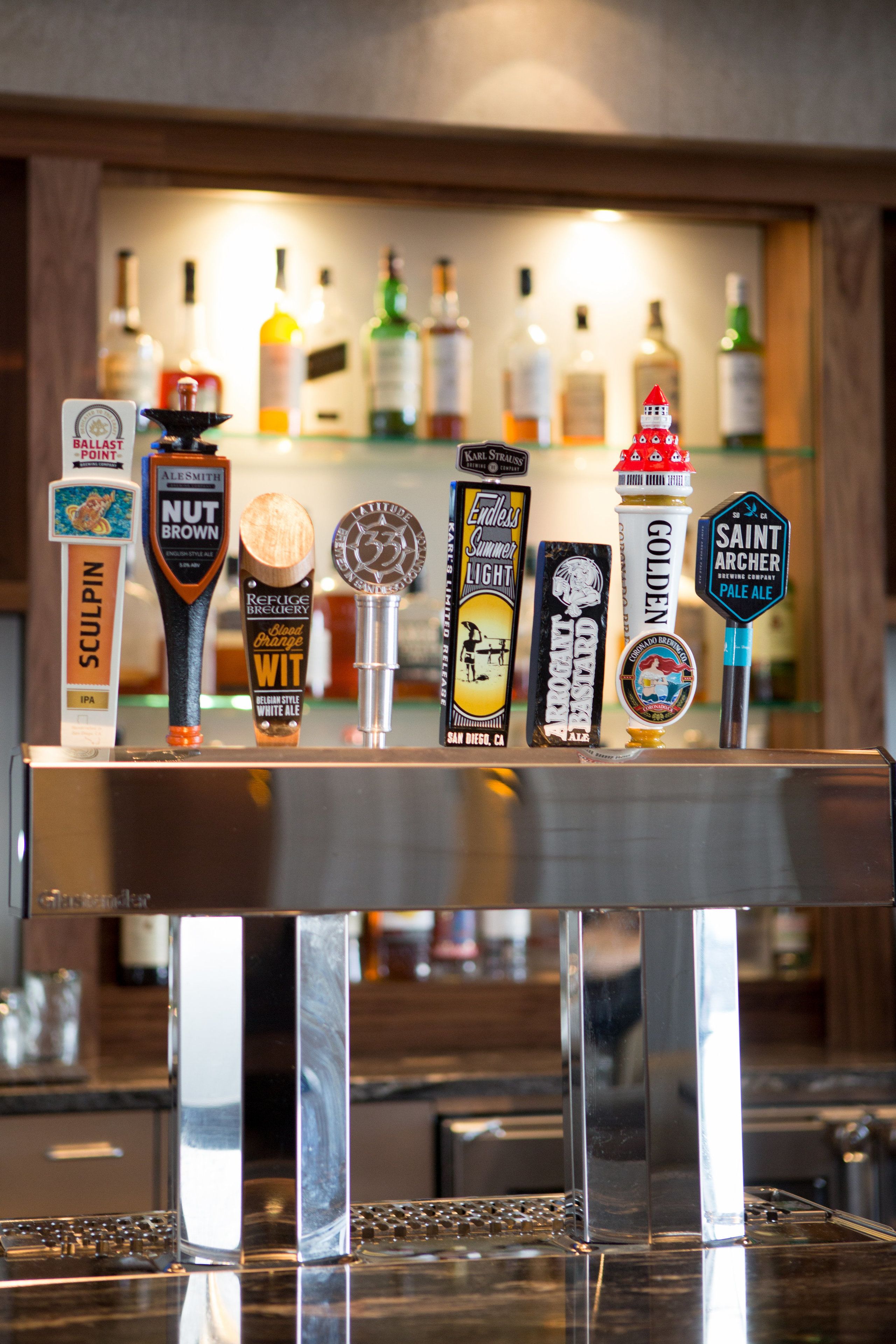 Un bar proposant une variété de bières à la pression, notamment des marques comme Ballast Point, Ale Smith Brown et Saint Archer Pale Ale.