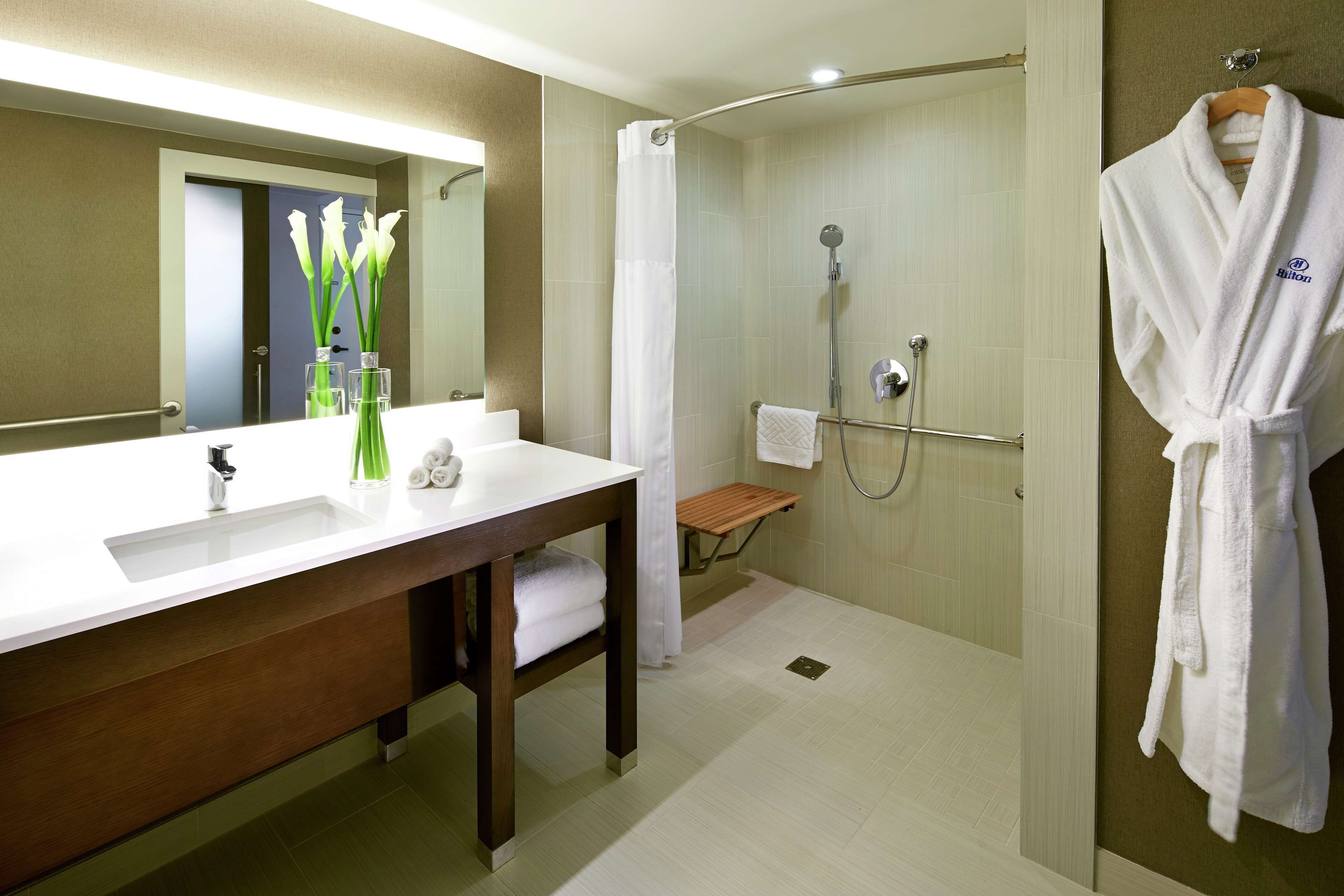 Un baño moderno con un lavabo grande, espejo y cabina de ducha.
