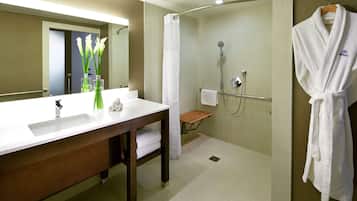 Un baño moderno con un lavabo grande, espejo y cabina de ducha.