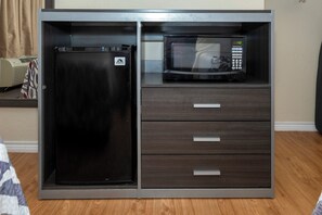 A compact kitchenette with a refrigerator and microwave. - Red Roof Inn Houston North - FM 1960 & I-45 (Houston)