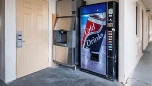 A vending machine with a Coca-Cola logo and a door with a handle.