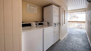 A laundry facility with a sign indicating it is for guest use only, and includes a commercial washer and dryer.