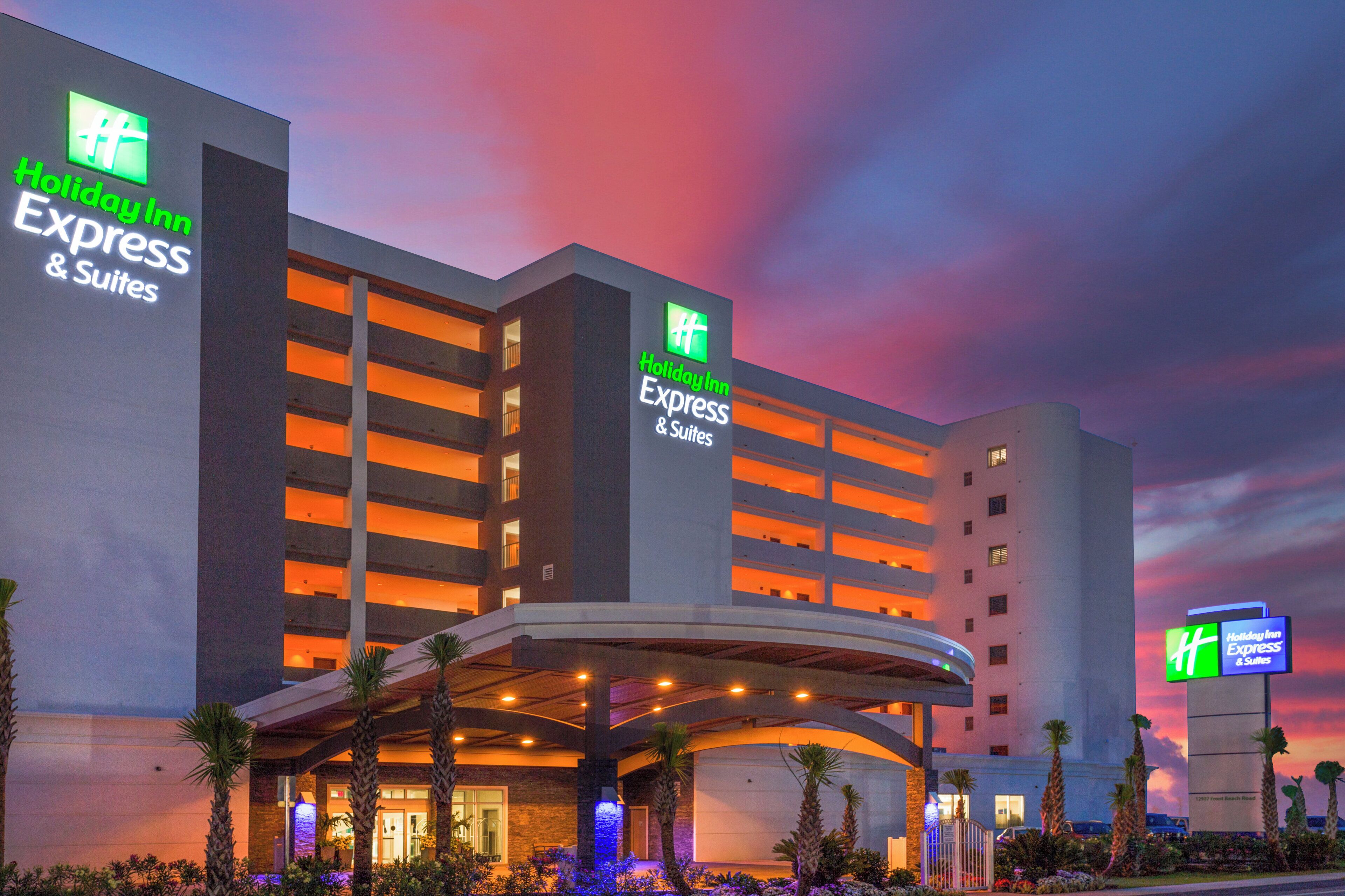 Un hotel Holiday Inn Express & Suites de diseño moderno, con varios balcones y un área de entrada cubierta.
