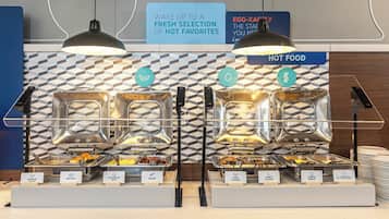 A buffet with labeled food stations including sausage gravy, biscuits, scrambled eggs, bacon, pork sausage, turkey sausage, cheese omelet, and egg white & veggie omelet.