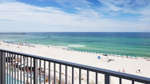 A beach view with a pier, a pool area, and beach umbrellas. - Holiday Inn Express & Suites Panama City Beach - Beachfront by IHG (Panama City Beach)