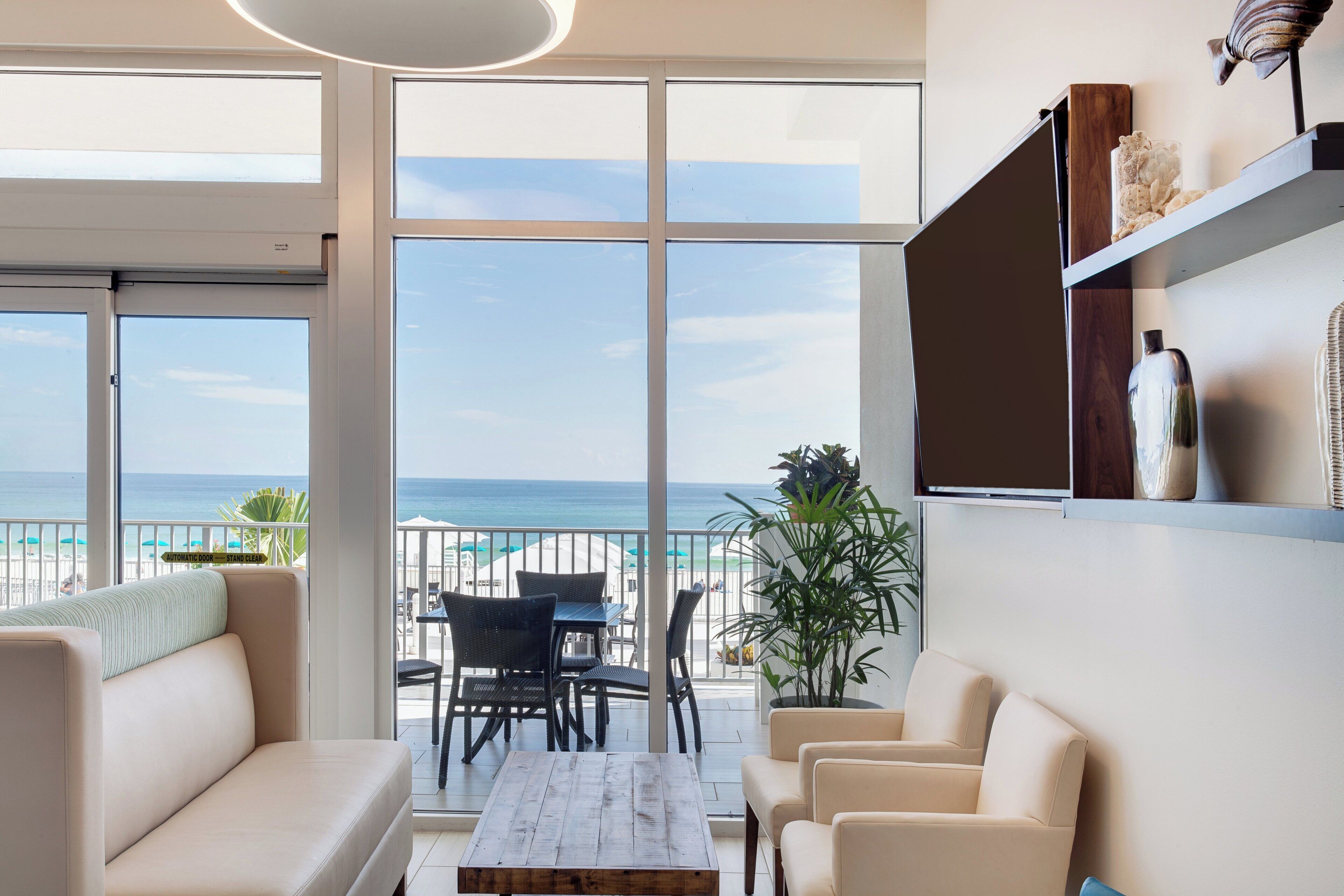 A modern living room with a view of the beach and ocean.