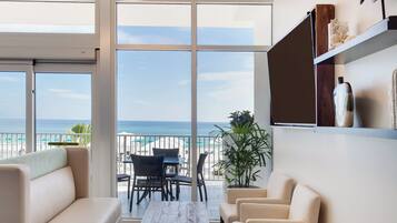 A modern living room with a view of the beach and ocean.