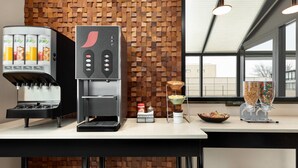 A coffee station with a coffee machine, a juice dispenser, and a beverage dispenser. - Super 8 by Wyndham Meadowlands (Carlstadt)