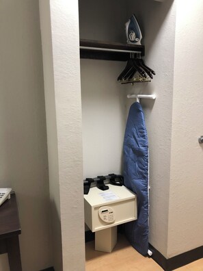 A small room with a white cabinet, a blue ironing board, and a wall-mounted ironing board. - Red Roof Inn Norwich (Norwich)