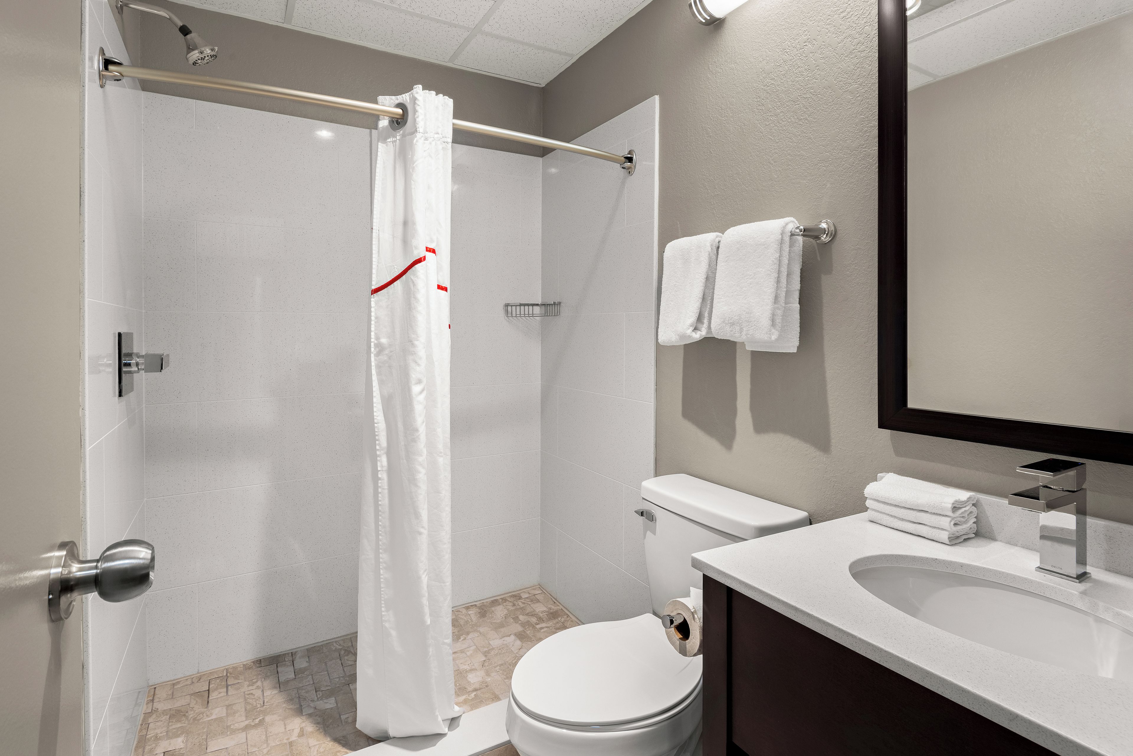 Un baño moderno con ducha, inodoro y lavamanos.
