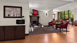 A lobby with a fireplace, seating area, and a television displaying 'Free Wi-Fi All Rooms'. - Red Roof Inn Norwich (Norwich)