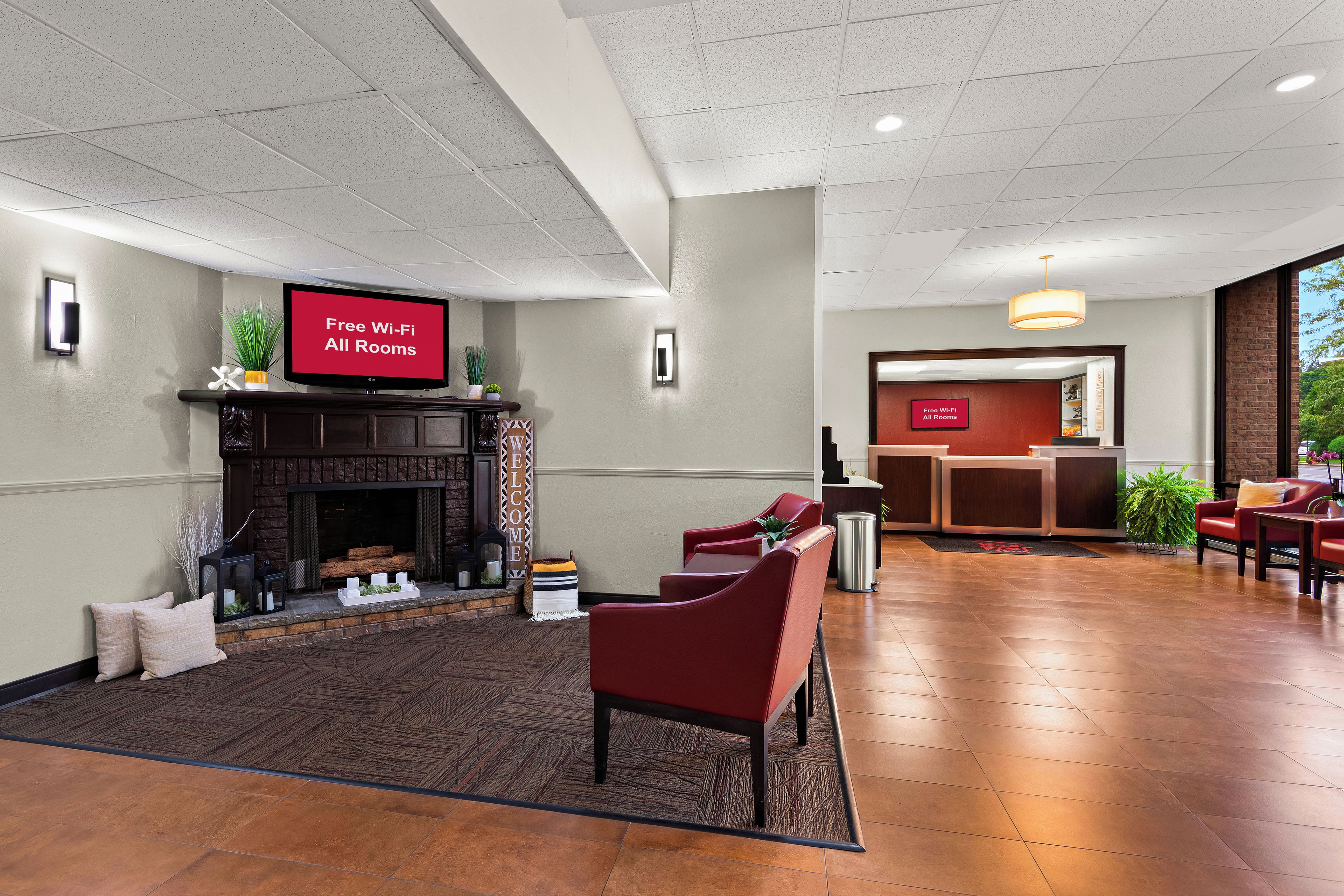A hotel lobby with a fireplace, seating area, and a reception desk.