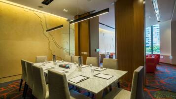 A conference room with a large table, chairs, and a carpeted floor.