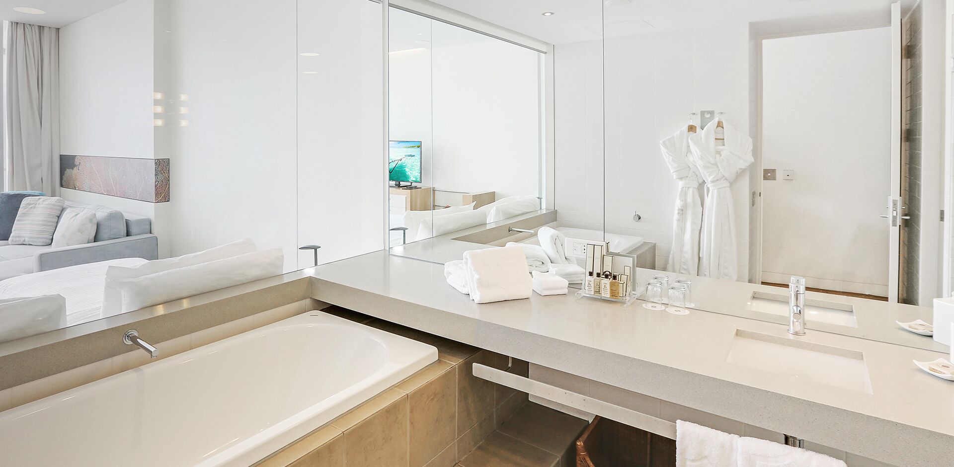 A modern bathroom with a large bathtub, a vanity with a mirror, and a shower area.