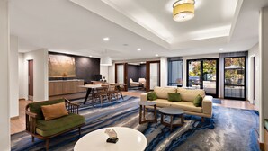 A spacious living area with a sofa, coffee table, and dining set. - Fairfield Inn and Suites By Marriott Chesapeake (Chesapeake)