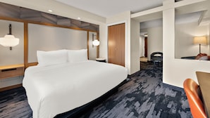 A hotel room with a large bed, a desk with a chair, a small table, and a lamp. - Fairfield Inn and Suites By Marriott Chesapeake (Chesapeake)