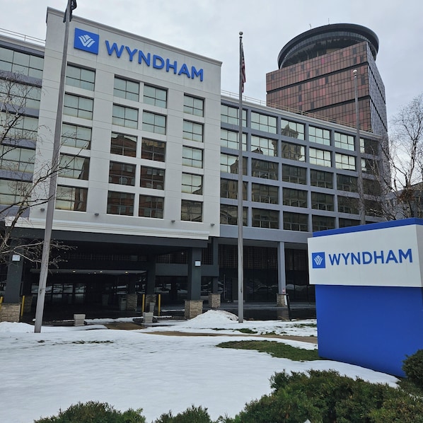 A Wyndham hotel building with a modern facade, large windows, and a prominent signage.