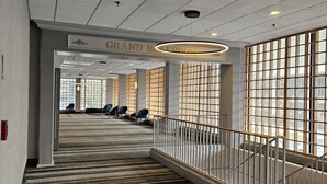 A hotel lobby with a grand staircase, a sign reading "GRAND BALLROOM", and a carpeted floor. - Wyndham Rochester Downtown (Rochester)