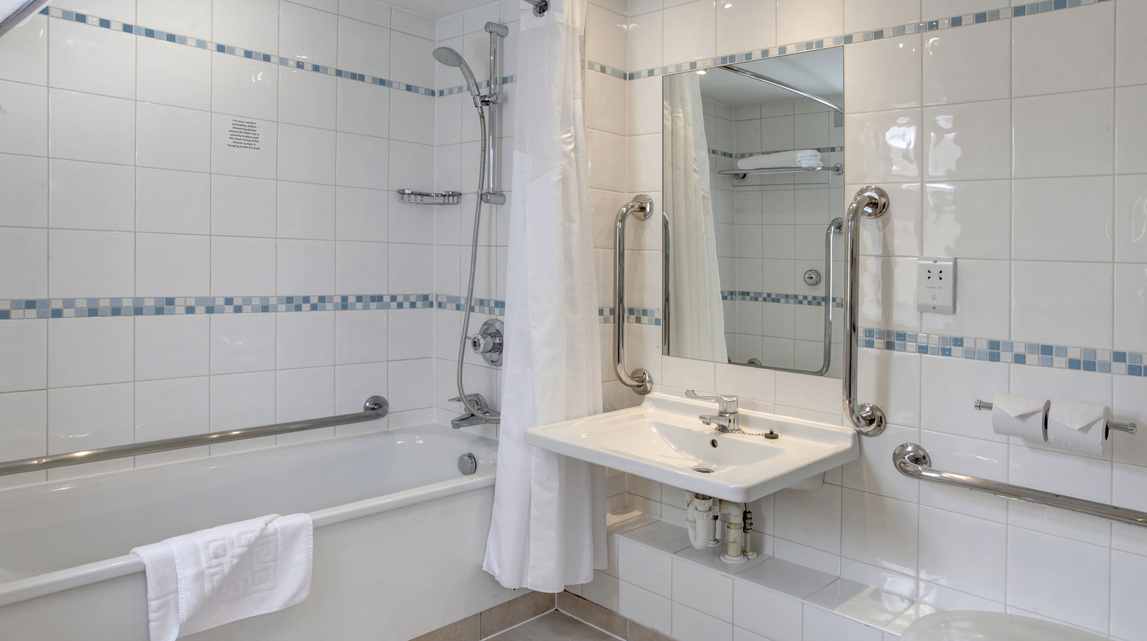 A modern bathroom with a bathtub, shower, and sink.