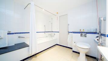 A bathroom with a bathtub, toilet, and sink.