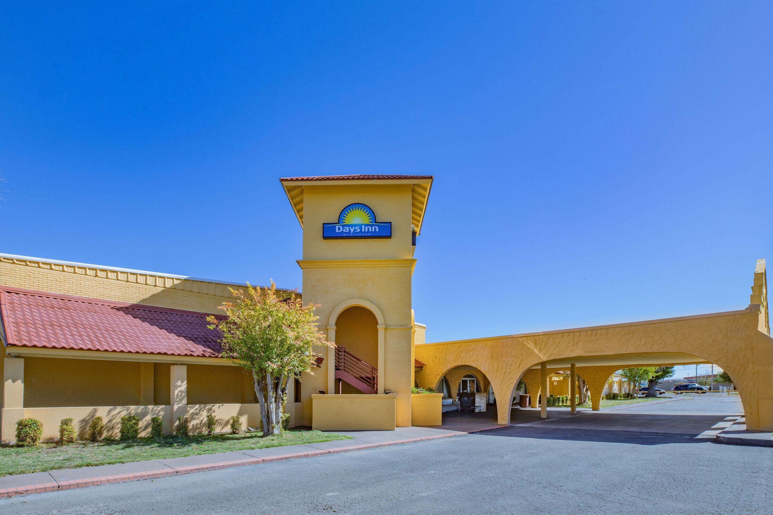 A Days Inn with a distinctive yellow facade and a red-tiled roof.