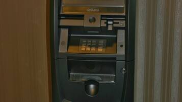 An ATM machine with a "Welcome" screen and "Get Cash" option, a card slot, and a keypad.