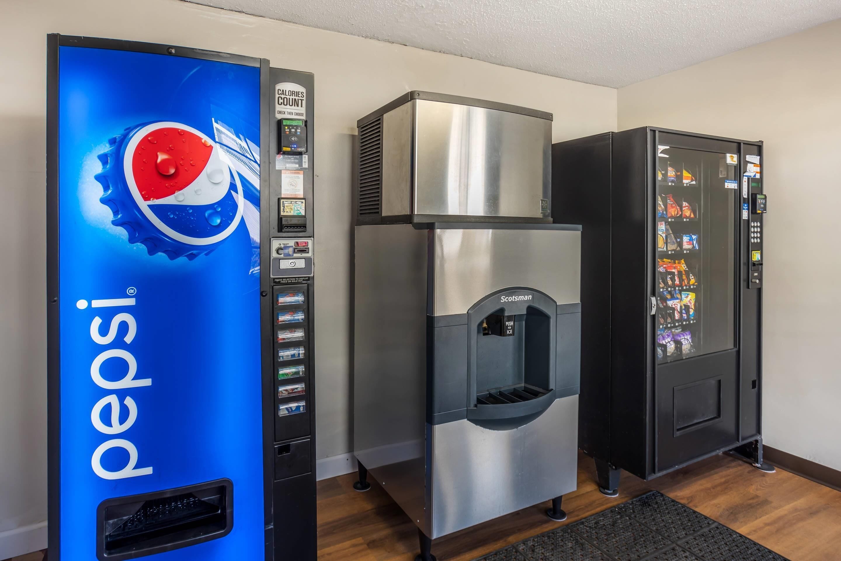 Una macchina distributrice con il logo Pepsi, un erogatore di acqua e un'altra macchina distributrice con diversi snack.