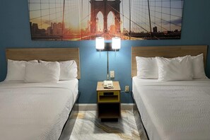 A hotel room with two beds, a nightstand with a lamp, and a cityscape mural on the wall. - Days Inn by Wyndham Jersey City / NYC Area (Jersey City)