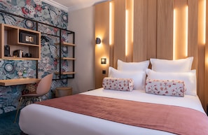 A hotel room with a large bed, a wooden headboard, a nightstand, a chair, and a shelf with books and a kettle. - Leonardo Boutique Hotel Paris Opera (Paris)