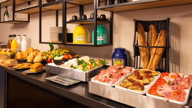 A buffet with various food items including bread, meats, and salads. - Leonardo Boutique Hotel Paris Opera (Paris)