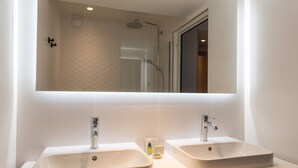 A bathroom with two sinks, a shower, and a large mirror. - Leonardo Boutique Hotel Paris Opera (Paris)