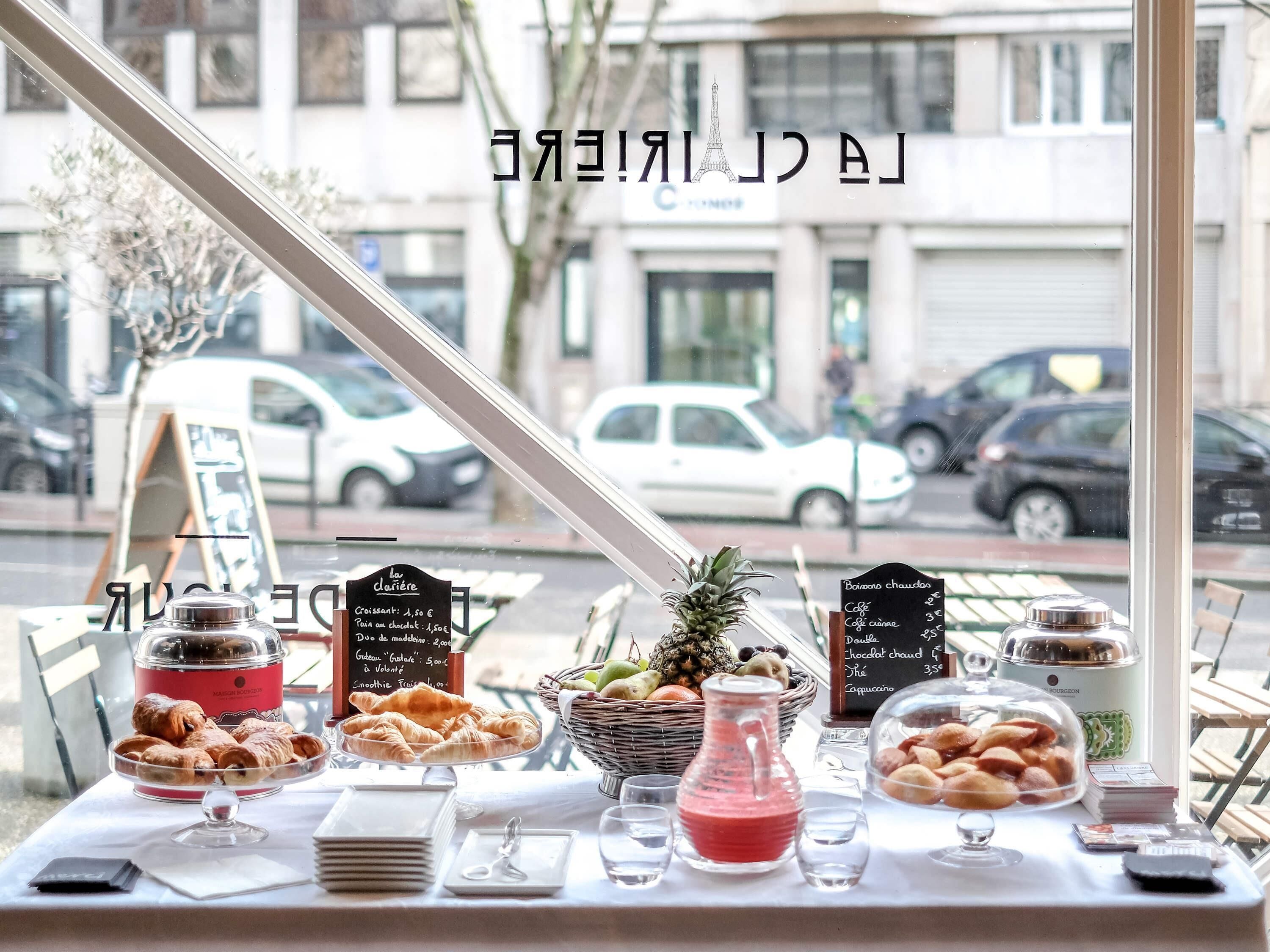A breakfast buffet with croissants, fruits, and beverages.