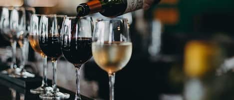 A hand pouring wine into a glass.