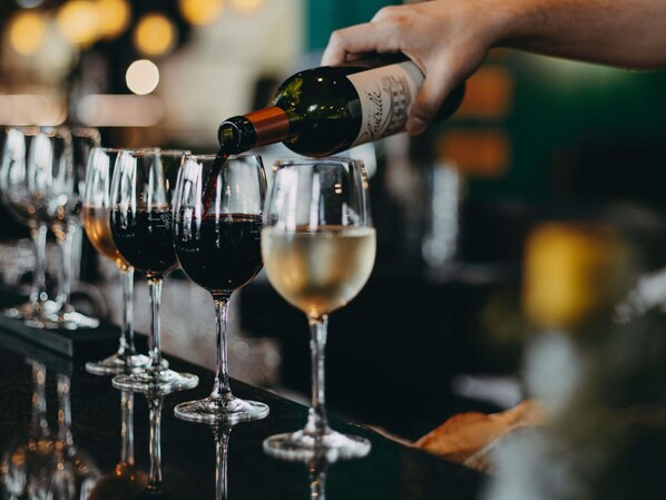 Une main versant du vin dans un verre.