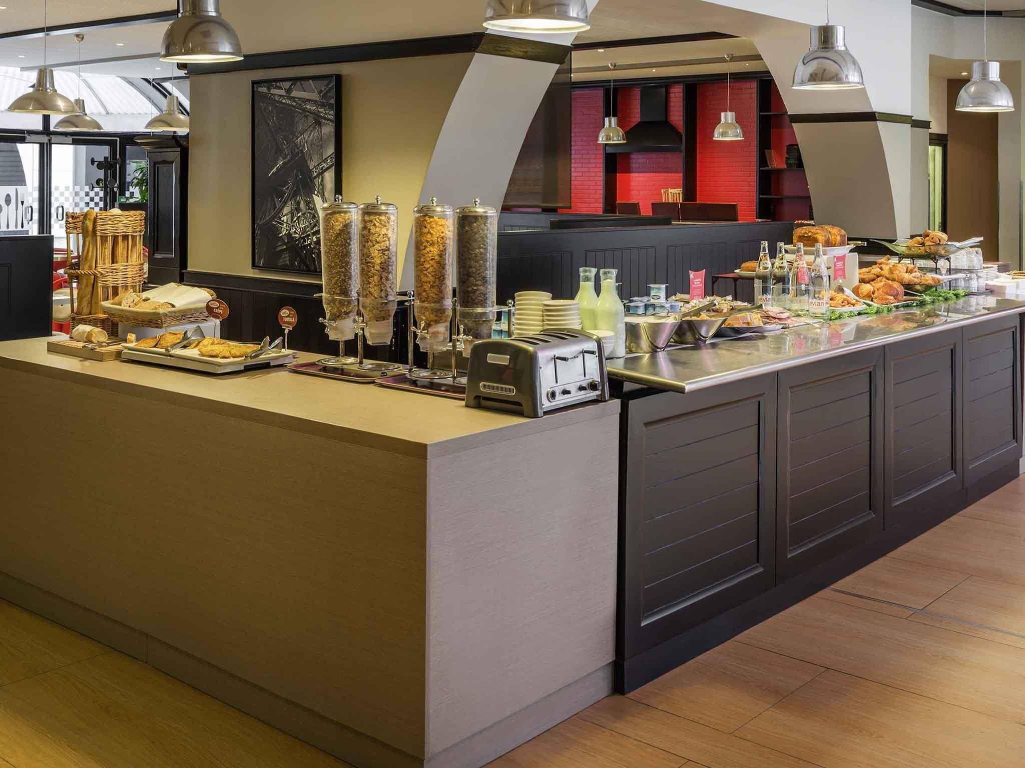 A buffet setup with various food items and a self-service station.