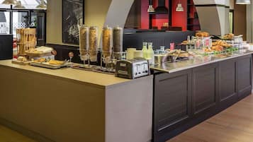 A buffet setup with various food items and a self-service station.