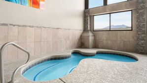 A spa area with a hot tub, a window with a mountain view, and a colorful abstract painting on the wall. - The Kendrick Hotel, an Ascend Collection Hotel (Flagstaff)